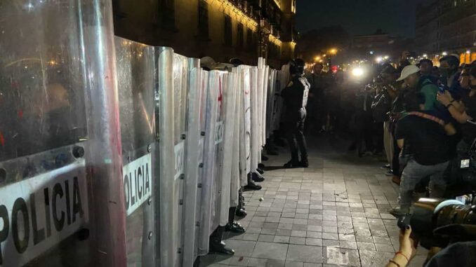 Enfrentamiento entre policías y manifestantes durante la vigilia en el Zócalo