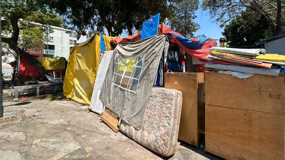 Migrantes reconstruyen campamento en la Venustiano Carranza tras desalojo